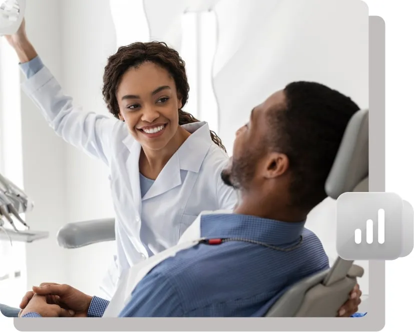Female dentist smiling and interacting with a patient.