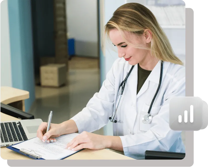 Female doctor writing patient notes at a desk.