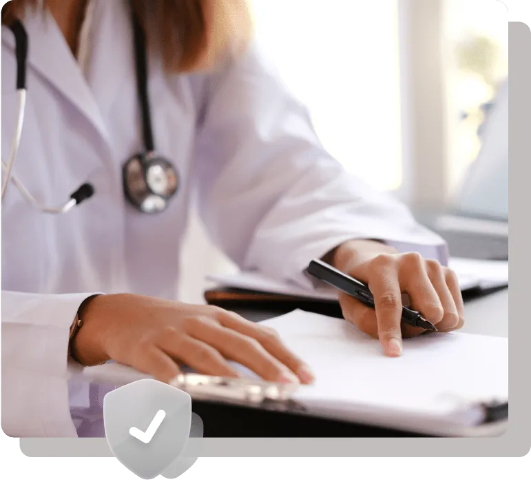 Healthcare professional writing on a clipboard with a stethoscope.