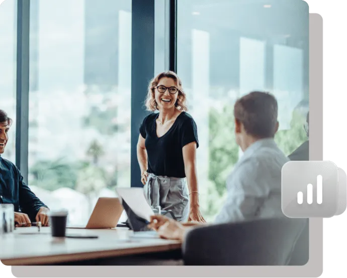 Smiling businesswoman presenting in a modern office meeting.