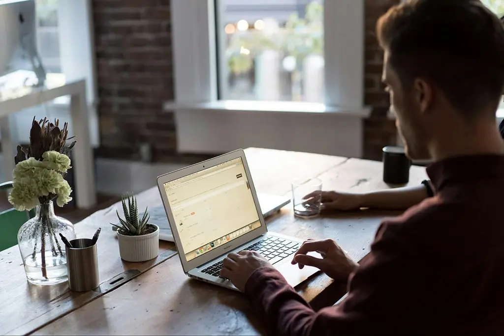 SEO professional using a laptop to determine whether they should use a backlink generator