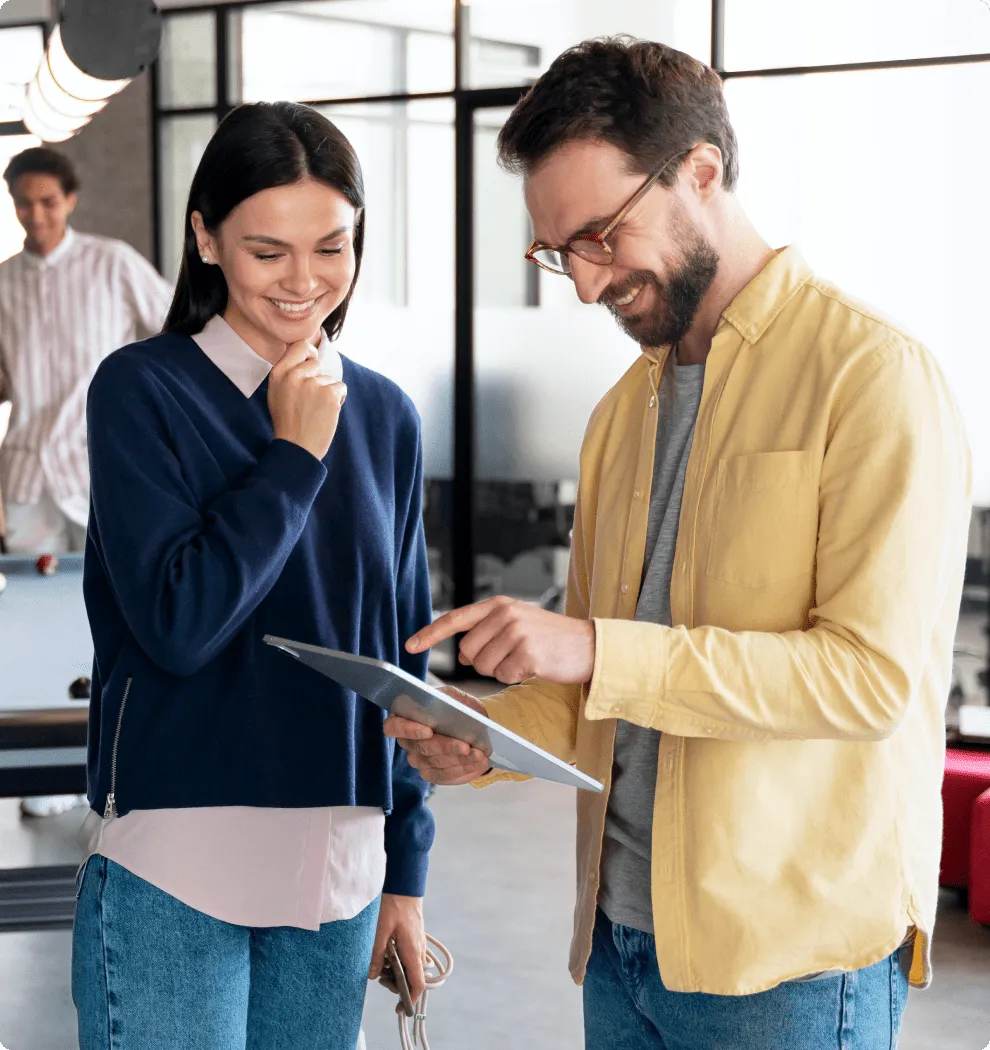 Coworkers collaborating around a tablet in a modern office