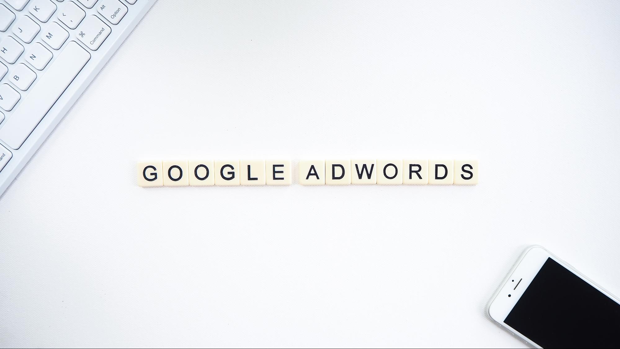 white background with top left corner showng a keyword, bottom left showing a smartphone and the words Google Adwords in the middle