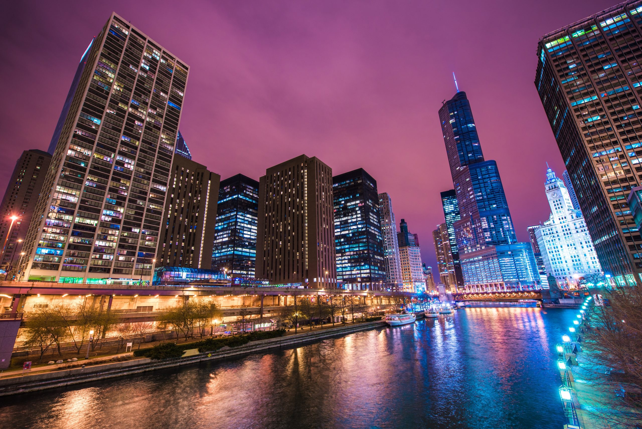 Chicago river at night offers a mesmerizing view with the glistening city lights reflecting on the water.