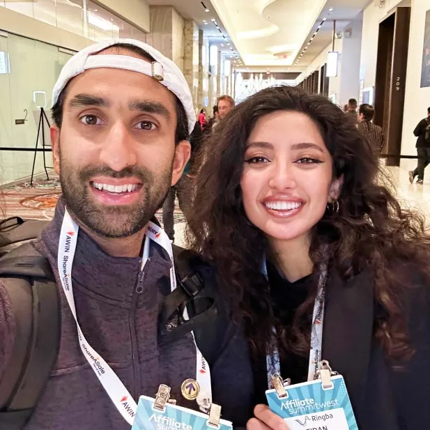 Manick Bhan and Fidan Alizada smiling at Affiliate Summit West conference wearing event badges