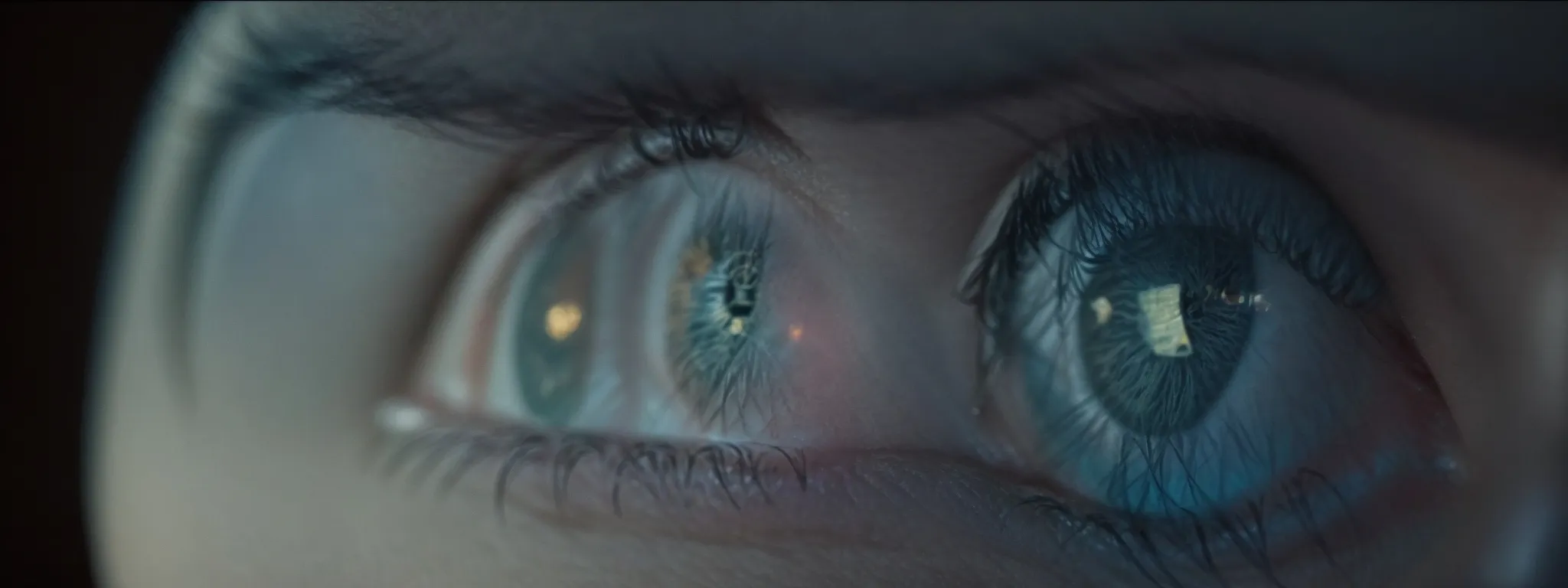 a close-up view of a person's eye reflecting a computer screen showing the google homepage.