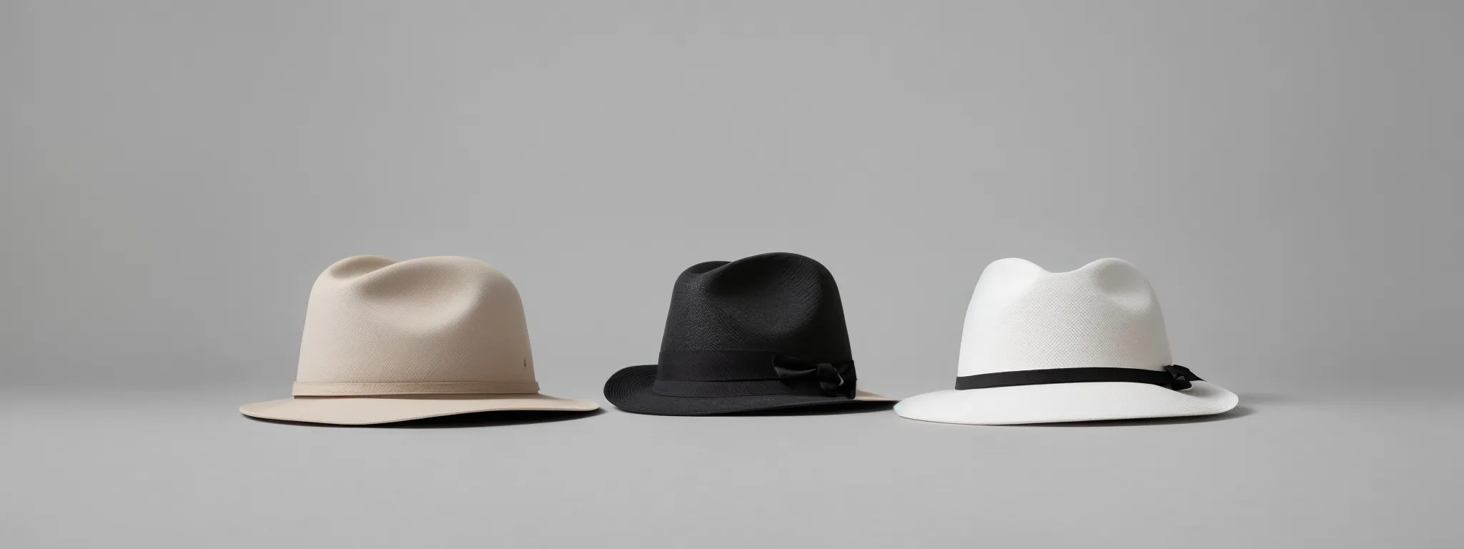 three distinguishable hats in black, white, and gray placed side by side on a plain surface, each representing a different seo strategy.
