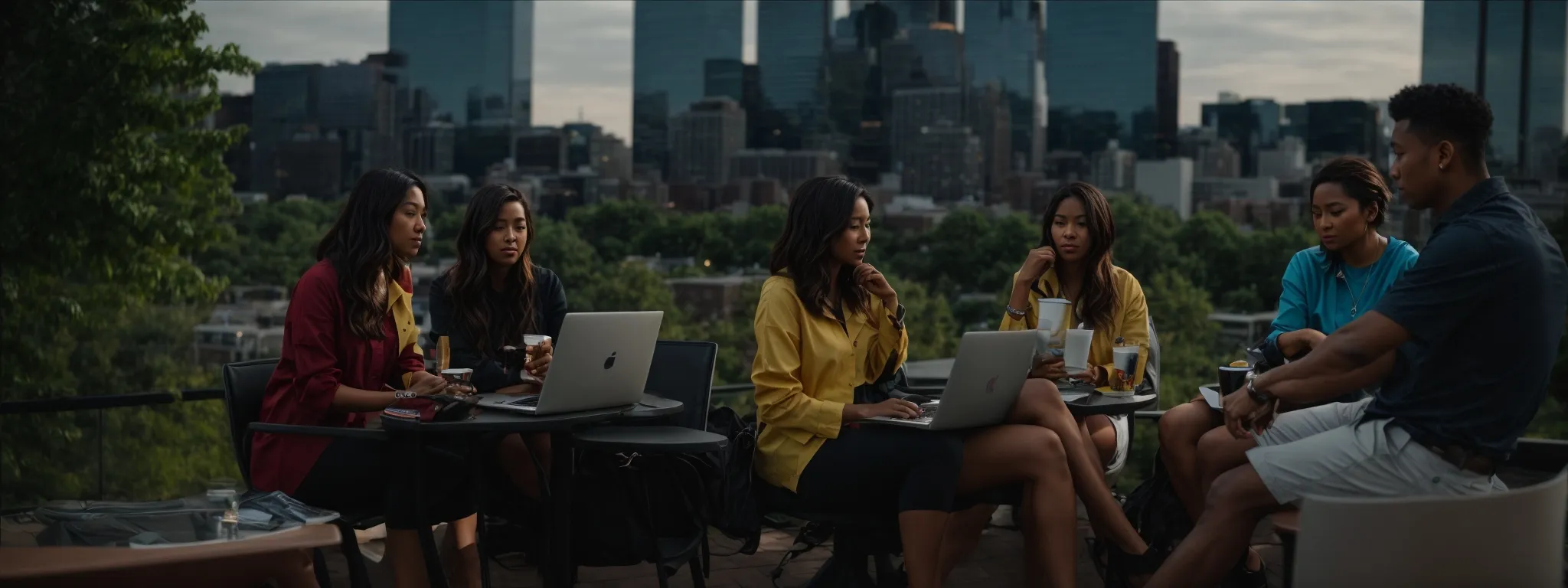 a group of professionals gathered around a laptop, discussing strategies with the iconic ann arbor skyline in the background.