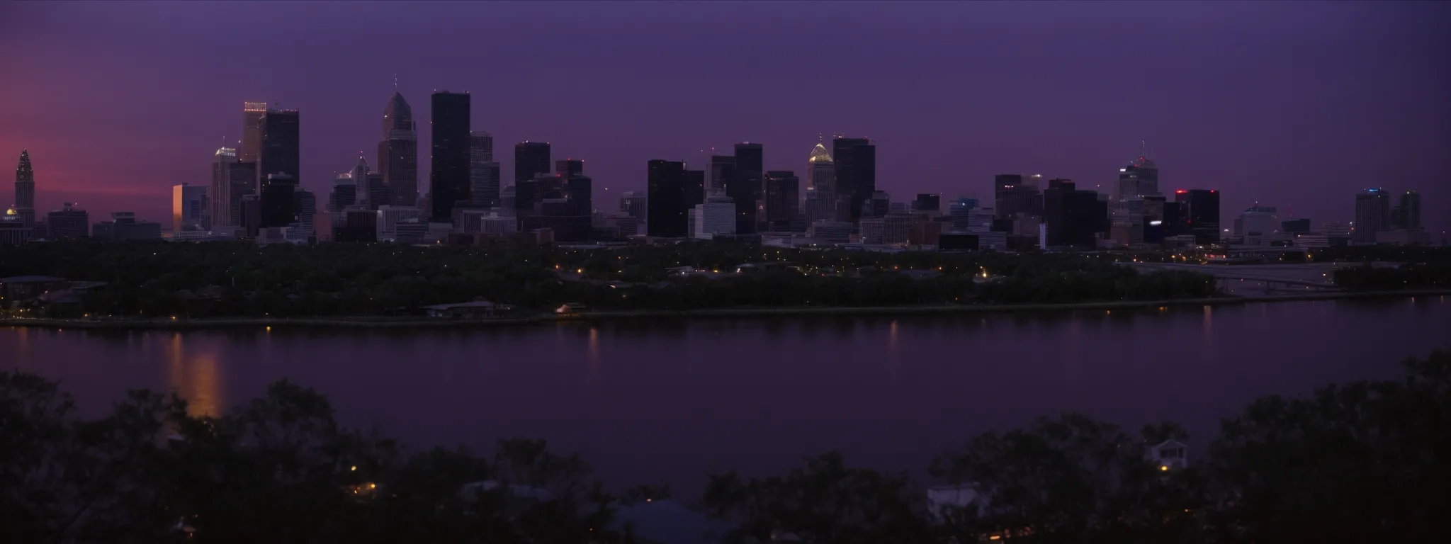 a panoramic view of the new orleans skyline at dusk, reflecting off the mississippi river.
