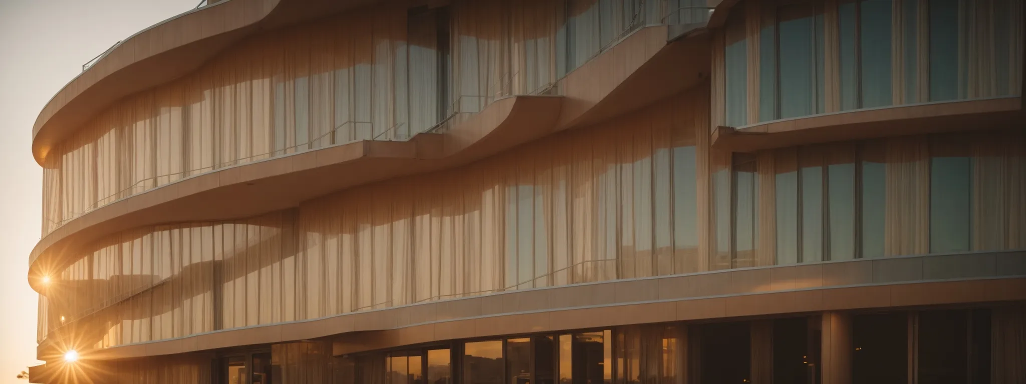 a modern hotel facade bathed in the warm glow of the setting sun.