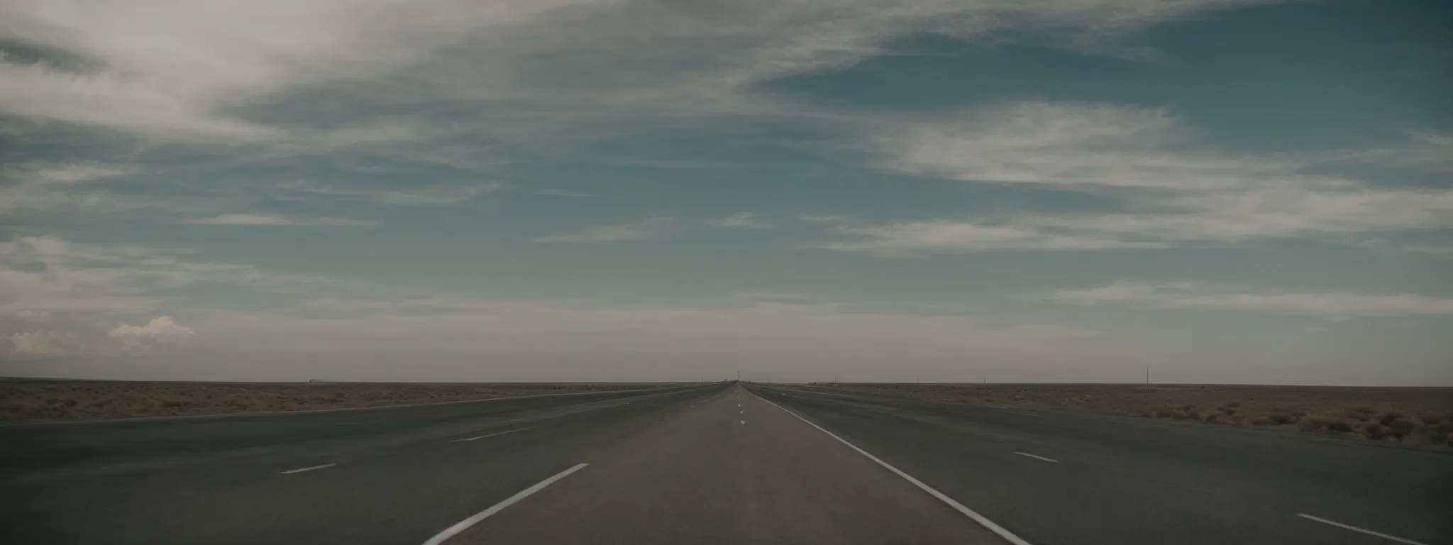 a deserted highway stretches into the horizon, silently challenging the belief that bustling roads equate to progress.